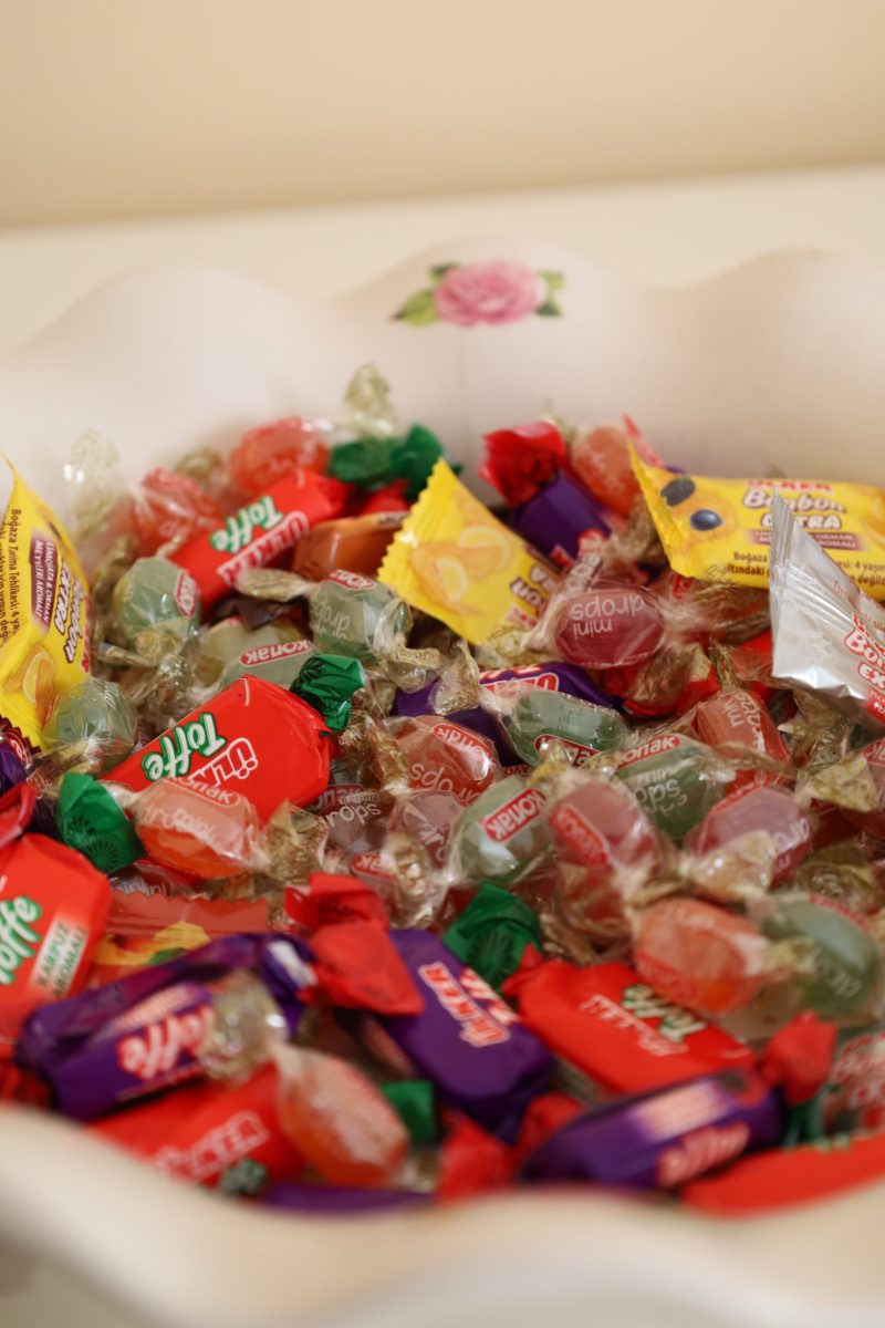 Vibrant assortment of wrapped hard candies in a decorative bowl.